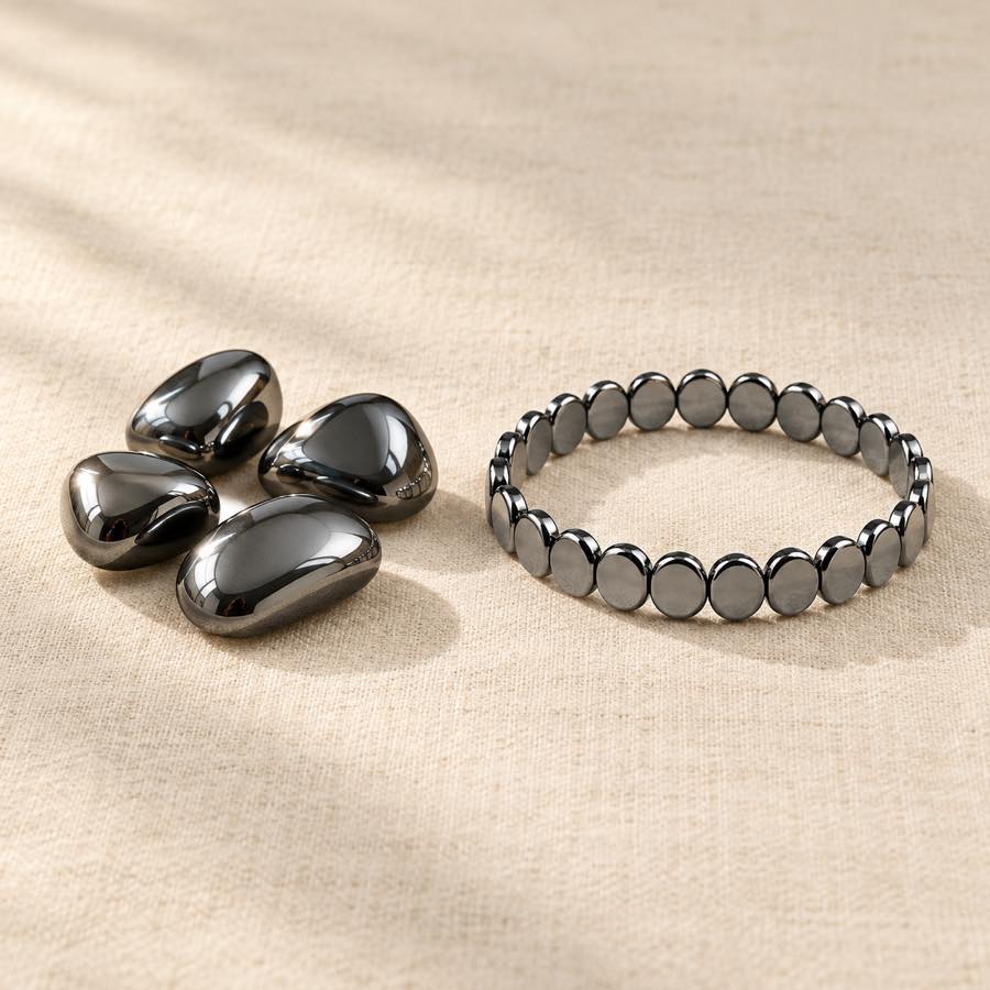 Polished hematite stones next to the dark HAIMA bracelet